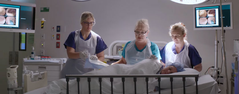 Dr Melissa White, flanked by two hospital staff, examines a patient in theatre at Buderim Private Hospital. 
