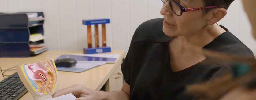 Image alt tags: Buderim Private Hospital gynaecologist Dr Beverley Powell shows a model of the female reproductive system to a patient. 